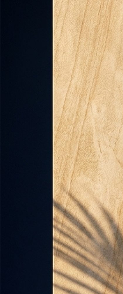 A sunlit stone column against a deep ground, with palm shadows